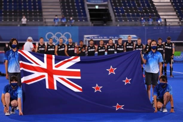 Flag bearers hold the flag of New Zealand as New Zealand players line up for their national anthem prior to the Men's Preliminary Pool A match...