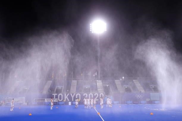 Belgium players warm up under the pitch sprinklers prior to the Men's Preliminary Pool B match between Belgium and Great Britain on day seven of the...