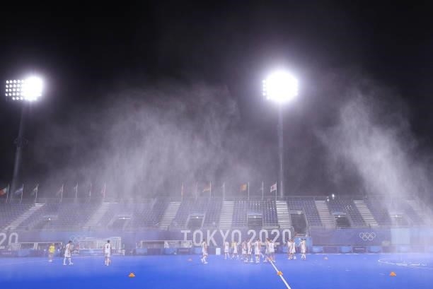 Belgium players warm up under the pitch sprinklers prior to the Men's Preliminary Pool B match between Belgium and Great Britain on day seven of the...
