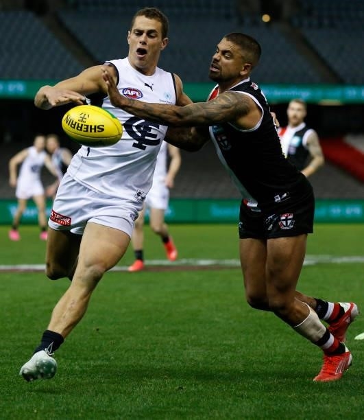 Ed Curnow of the Blues kicks the ball as Bradley Hill of the Saints attempts to smother during the round 20 AFL match between St Kilda Saints and...