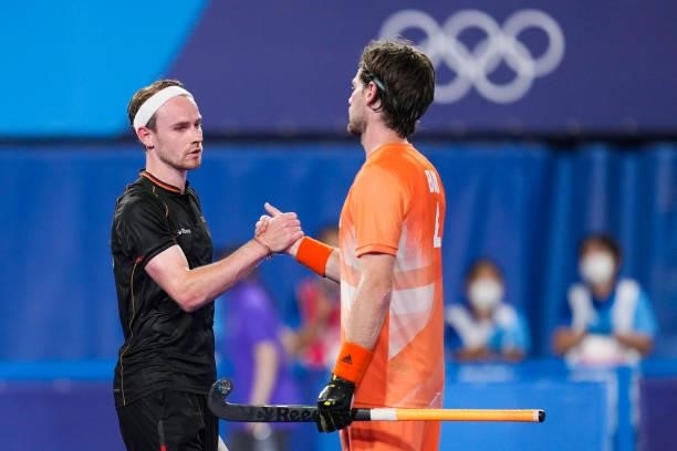 Jan Christopher Ruhr of Germany and Lars Balk of the Netherlands shake hands while competing on Men's Pool B during the Tokyo 2020 Olympic Games at...