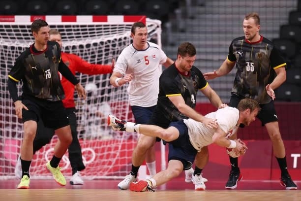 Magnus Gullerud of Team Norway is challenged by Johannes Golla of Team Germany as he falls to the ground during the Men's Preliminary Round Group A...