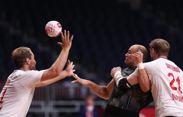Paul Drux of Team Germany is challenged by Petter Oeverby and Magnus Gullerud of Team Norway during the Men's Preliminary Round Group A handball...