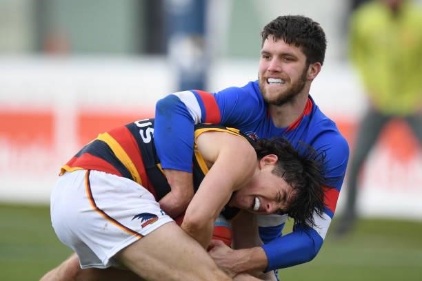 Bailey Williams of the Bulldogs tackles Ned McHenry of the Crows during the round 19 AFL match between Western Bulldogs and Adelaide Crows at Mars...