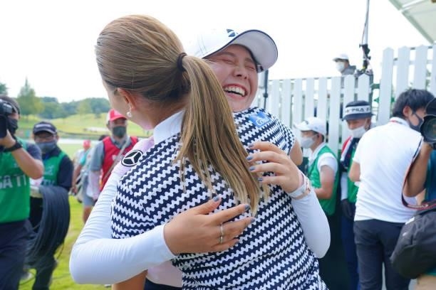 Yuri Yoshida of Japan is congratulated by Momoko Ueda after winning the tournament on the 18th green during the final round of Rakuten Super Ladies...