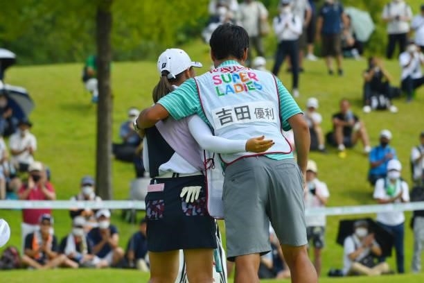 Yuri Yoshida of Japan is congratulated by her caddie after winning the tournament on the 18th green during the final round of Rakuten Super Ladies at...