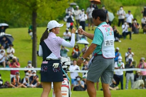 Yuri Yoshida of Japan is congratulated by her caddie after winning the tournament on the 18th green during the final round of Rakuten Super Ladies at...