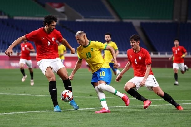 Richarlison of Team Brazil battles for possession with Ahmed Hegazy and Osama Galal of Team Egypt during the Men's Quarter Final between Brazil and...