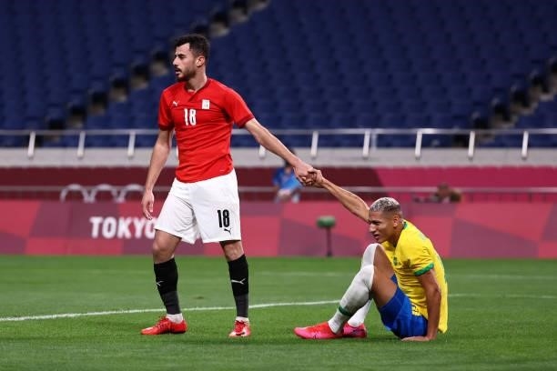 Richarlison of Team Brazil is helped up by Mahmoud El Wench of Team Egypt during the Men's Quarter Final between Brazil and Egypt on day eight of the...