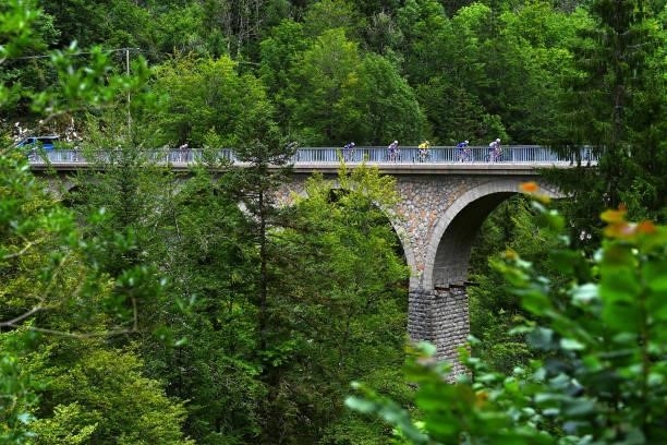 General view of the peloton & Georg Zimmermann of Germany and Team Intermarché - Wanty - Gobert Matériaux Yellow Leader Jersey passing a bridge...