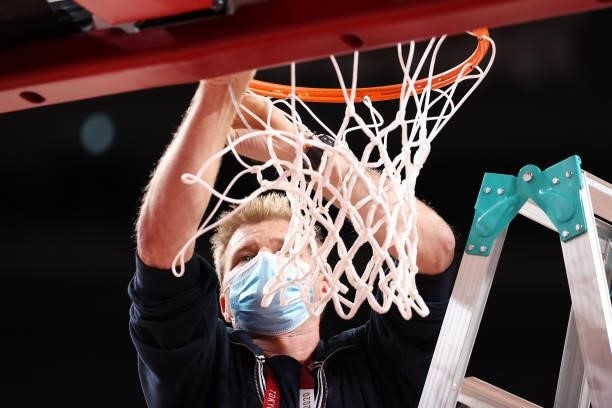 An arena worker cuts down the net following the Men's Basketball Preliminary Round Group A game between the United States and Czech Republic on day...