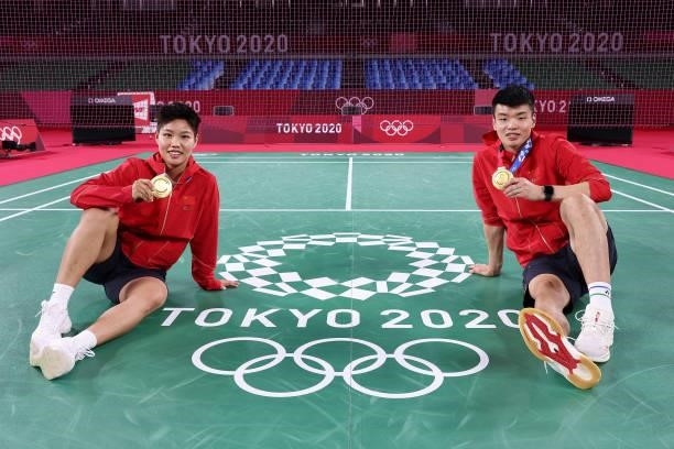 Gold medalists Wang Yi Lyu and Huang Dong Ping of Team China pose with their medals after winning the Mix Doubles badminton event on day eight of the...
