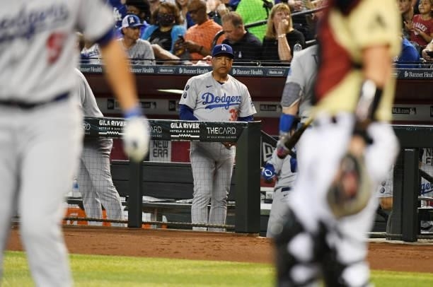 Manager Dave Roberts of the Los Angeles Dodgers looks on from the dugout against the Arizona Diamondbacks at Chase Field on July 30, 2021 in Phoenix,...