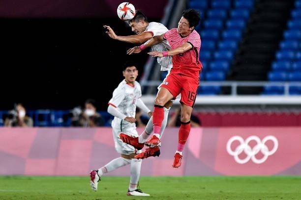 Cesar Montes of Mexico competes for the headed ball with Ui-jo Hwang of South Korea during the Men's Football Tournament Quarter Final match between...