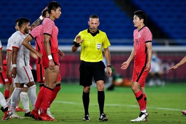 Tae-wook Jeong of South Korea, Referee Orel Grinfeeld of Israel and Dong-hyun Kim of South Korea during the Men's Football Tournament Quarter Final...