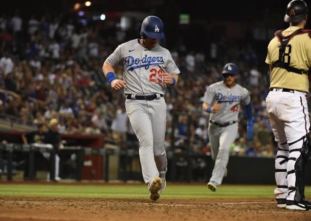 Billy McKinney of the Los Angeles Dodgers scores on a two run triple by Chris Taylor against the Arizona Diamondbacks during the seventh inning at...