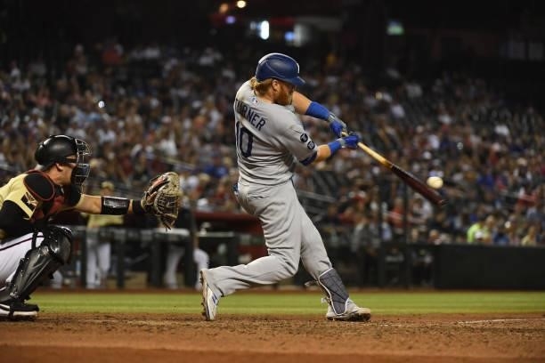 Justin Turner of the Los Angeles Dodgers makes contact with a pitch against the Arizona Diamondbacks at Chase Field on July 30, 2021 in Phoenix,...