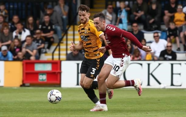 Dylan Connolly of Northampton Town moves with the ball away from Jack Iredale of Cambridge United during the Pre Season Friendly match between...