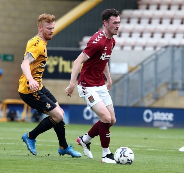 Paul Lewis of Northampton Town moves with the ball away from Liam O'Neil of Cambridge United during the Pre Season Friendly match between Cambridge...