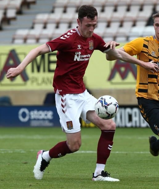 Paul Lewis of Northampton Town controls the ball under pressure from Adam May of Cambridge United during the Pre Season Friendly match between...