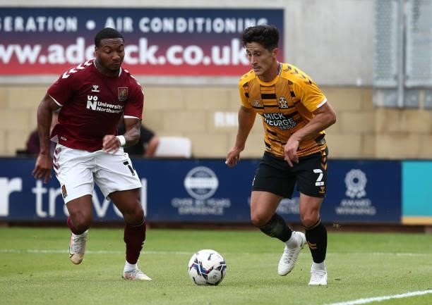 George Williams of Cambridge United moves with the ball watched by Ali Koiki of Northampton Town during the Pre Season Friendly match between...