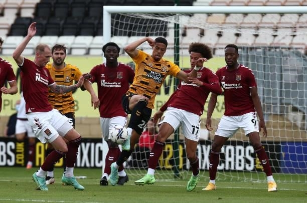 Harvey Knibbs of Cambridge United contests the ball with Shaun McWilliams and Mitch Pinnock of Northampton Town during the Pre Season Friendly match...