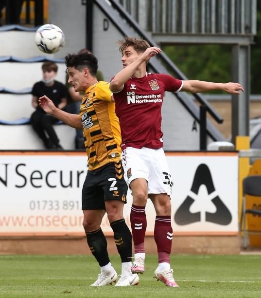 George Williams of Cambridge United heads the ball under pressure from Danny Rose of Northampton Town during the Pre Season Friendly match between...