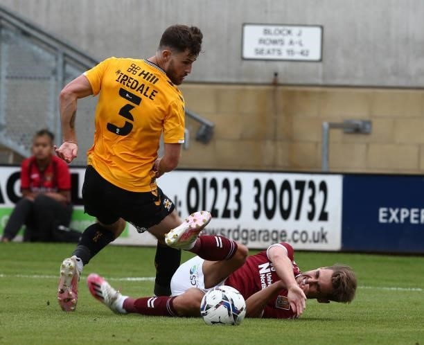 Danny Rose of Northampton Town goes to ground under the challenge of Jack Iredale of Cambridge United during the Pre Season Friendly match between...