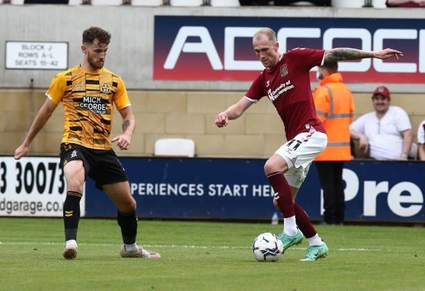Mitch Pinnock of Northampton Town controls the ball watched by Jack Iredale of Cambridge United during the Pre Season Friendly match between...
