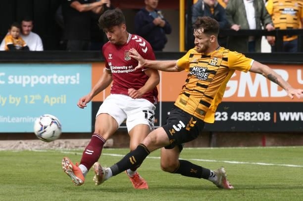 Scott Pollock of Northampton Town attempts to play the ball past Jack Iredale of Cambridge United during the Pre Season Friendly match between...
