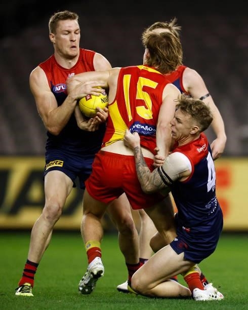 Noah Anderson of the Suns is tackled by James Harmes of the Demons and Tom McDonald of the Demons during the round 20 AFL match between Gold Coast...