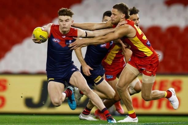 Bayley Fritsch of the Demons breaks a tackle attempt from Jy Farrar of the Suns during the round 20 AFL match between Gold Coast Suns and Melbourne...