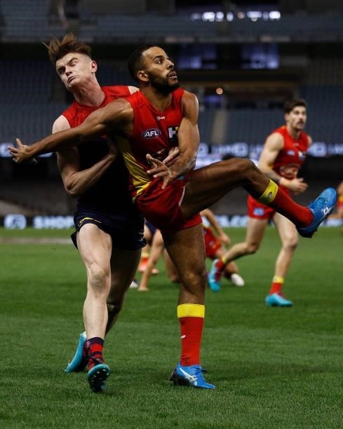 Touk Miller of the Suns kicks the ball under pressure from Bayley Fritsch of the Demons during the round 20 AFL match between Gold Coast Suns and...