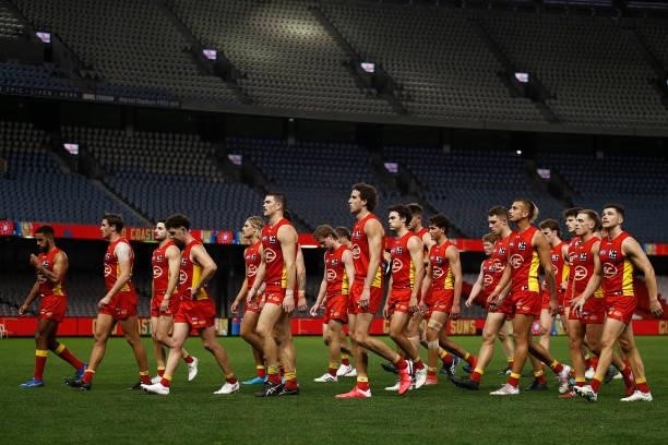 Suns players look dejected as they leave the field after the round 20 AFL match between Gold Coast Suns and Melbourne Demons at Marvel Stadium on...