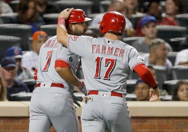 Eugenio Suarez of the Cincinnati Reds celebrates his fourth inning three run home run against the New York Mets with teammate Kyle Farmer at Citi...