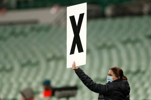 An Essendon staffer holds up a sign indicated the team has used all of its interchanges during the round 20 AFL match between Essendon Bombers and...