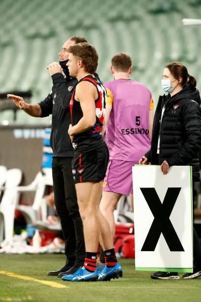 Essendon medical sub Brayden Ham looks on from the bench as Essendon tries to get him on the ground in the final minutes after using all there...