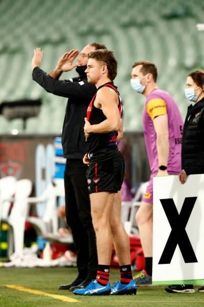 Ben Rutten, Senior Coach of the Bombers signals from the bench that there are no interchanges left while medical sub Brayden Ham looks on as Essendon...