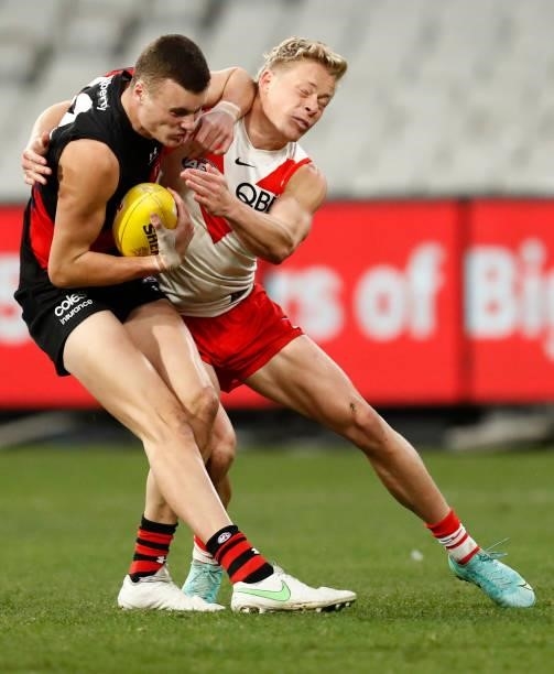 Nikolas Cox of the Bombers collects Isaac Heeney of the Swans high in a fend off during the round 20 AFL match between Essendon Bombers and Sydney...