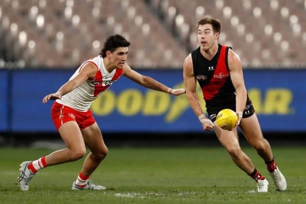 Zach Merrett of the Bombers handballs during the round 20 AFL match between Essendon Bombers and Sydney Swans at Melbourne Cricket Ground on August...