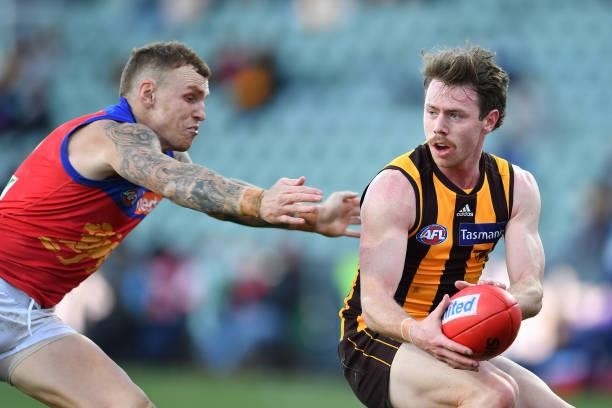 Lachlan Bramble of the Hawks is tackled by Mitch Robinson of the Lions during the round 19 AFL match between Hawthorn Hawks and Brisbane Lions at...