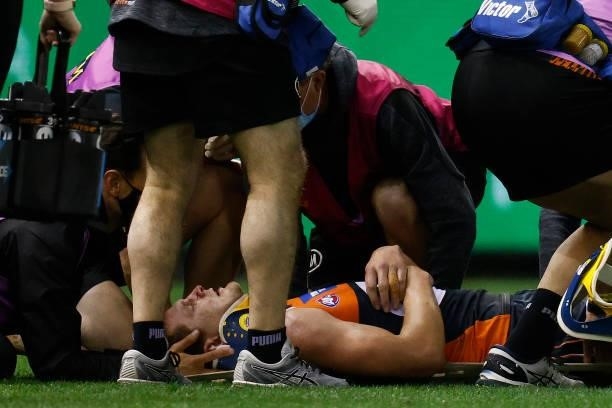 Jacob Hopper of the Giants receives medical attention after being knocked unconscious during the round 20 AFL match between Greater Western Sydney...