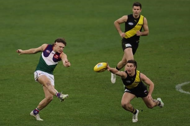 Liam Baker of the Tigers smothers the kick by Caleb Serong of the Dockers during the round 20 AFL match between Fremantle Dockers and Richmond Tigers...