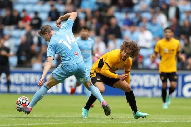 Ben Sheaf of Coventry City is challenged by Fabio Silva of Wolverhampton Wanderers during the Pre-Season friendly match between Coventry City and...