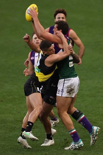 Lloyd Meek of the Dockers gets tackled by Jack Graham and Dion Prestia of the Tigers during the round 20 AFL match between Fremantle Dockers and...