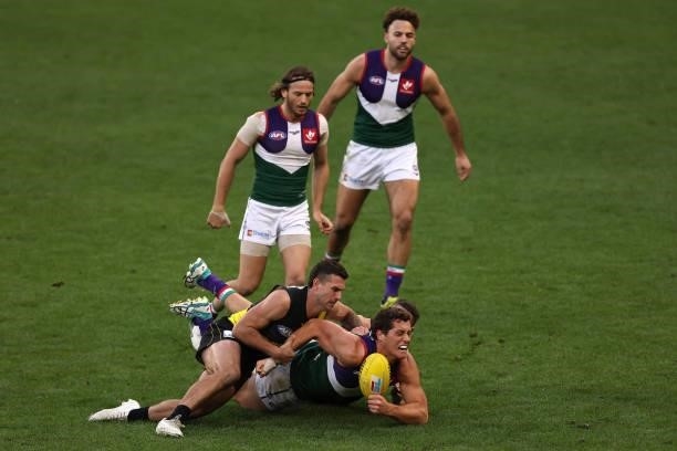 Lloyd Meek of the Dockers gets tackled by Jack Graham and Dion Prestia of the Tigers during the round 20 AFL match between Fremantle Dockers and...