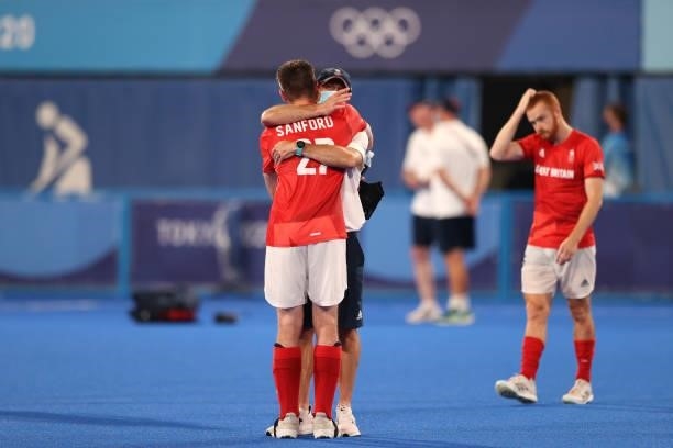 Liam Sanford of Team Great Britain is embraced by a Great Britain Member of Staff following a loss in the Men's Quarterfinal match between India and...