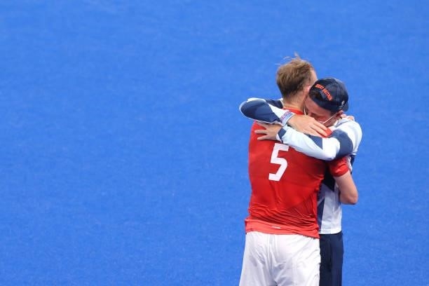 David Ames of Team Great Britain is embraced by a Team Great Britain Member of Staff following a loss in the Men's Quarterfinal match between India...