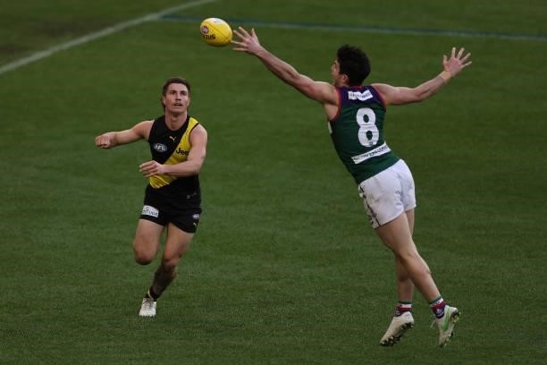 Andrew Brayshaw of the Dockers looks to cut off the handball by Liam Baker of the Tigers during the round 20 AFL match between Fremantle Dockers and...