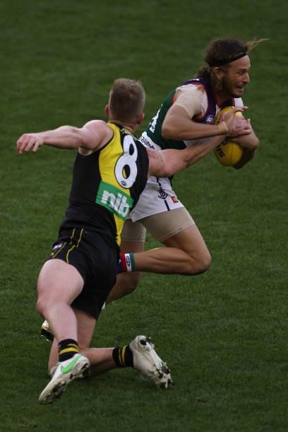 James Aish of the Dockers breaks from a tackle by Jack Riewoldt of the Tigers during the round 20 AFL match between Fremantle Dockers and Richmond...